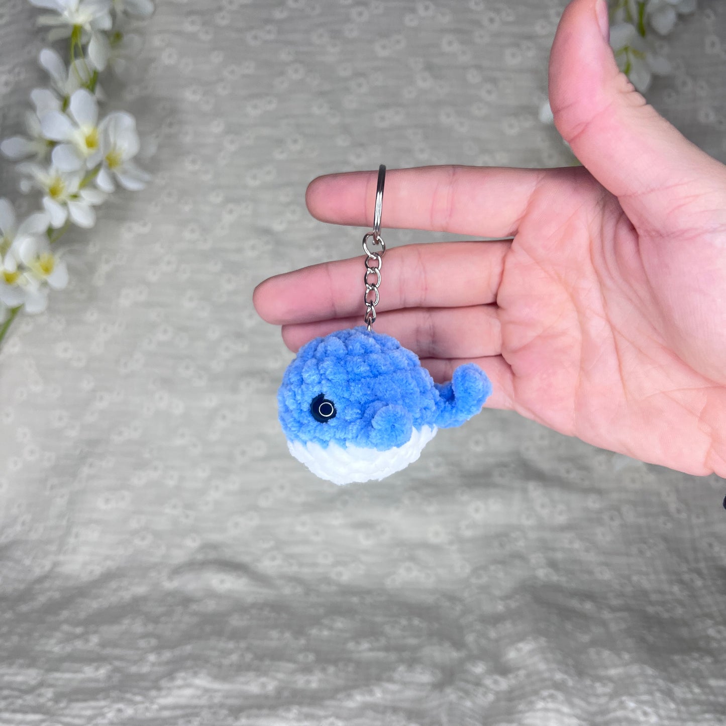 Porte-clés de couleur argent avec une baleine bleue et blanche en crochet
