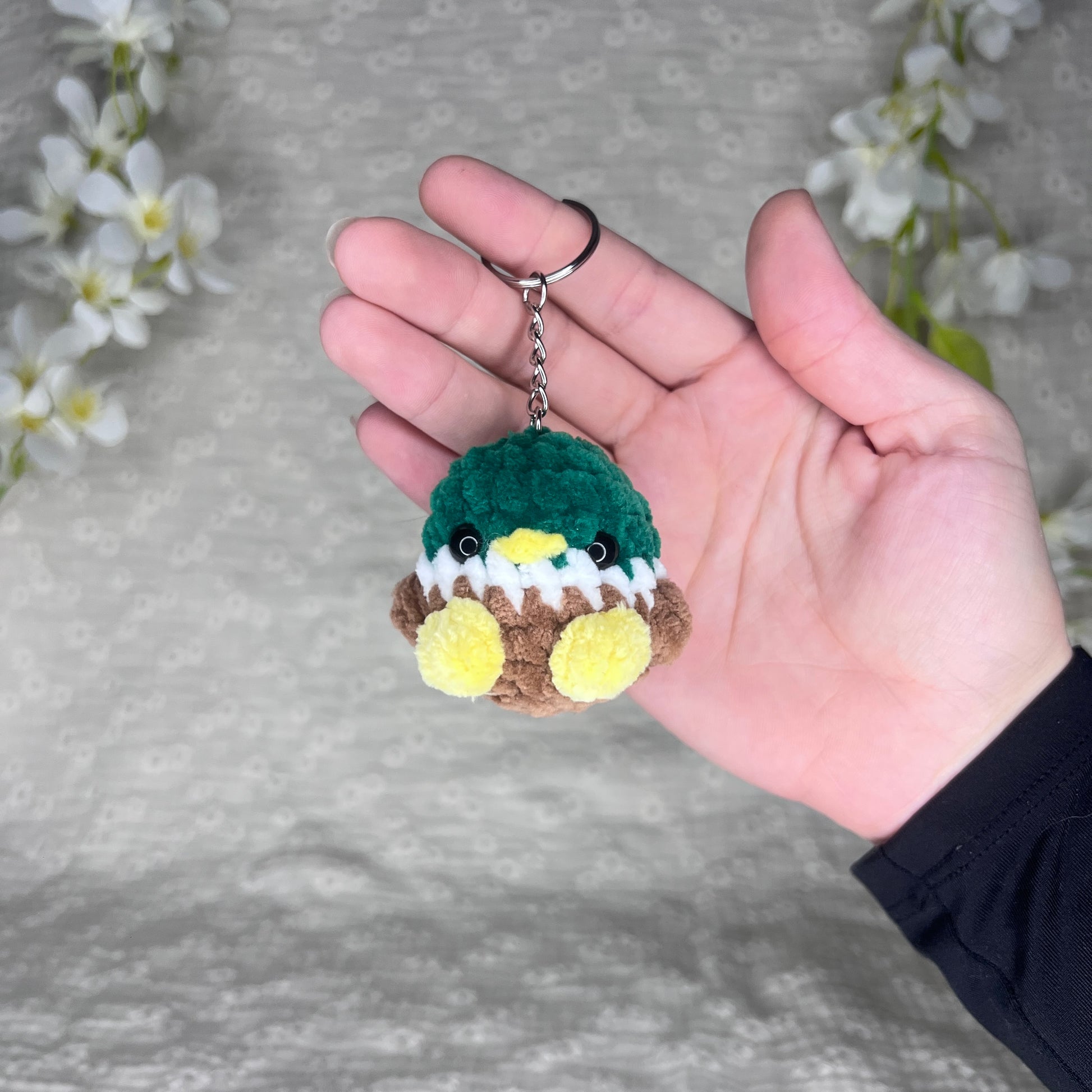 Porte-clés couleur argent avec un petit canard en crochet vert