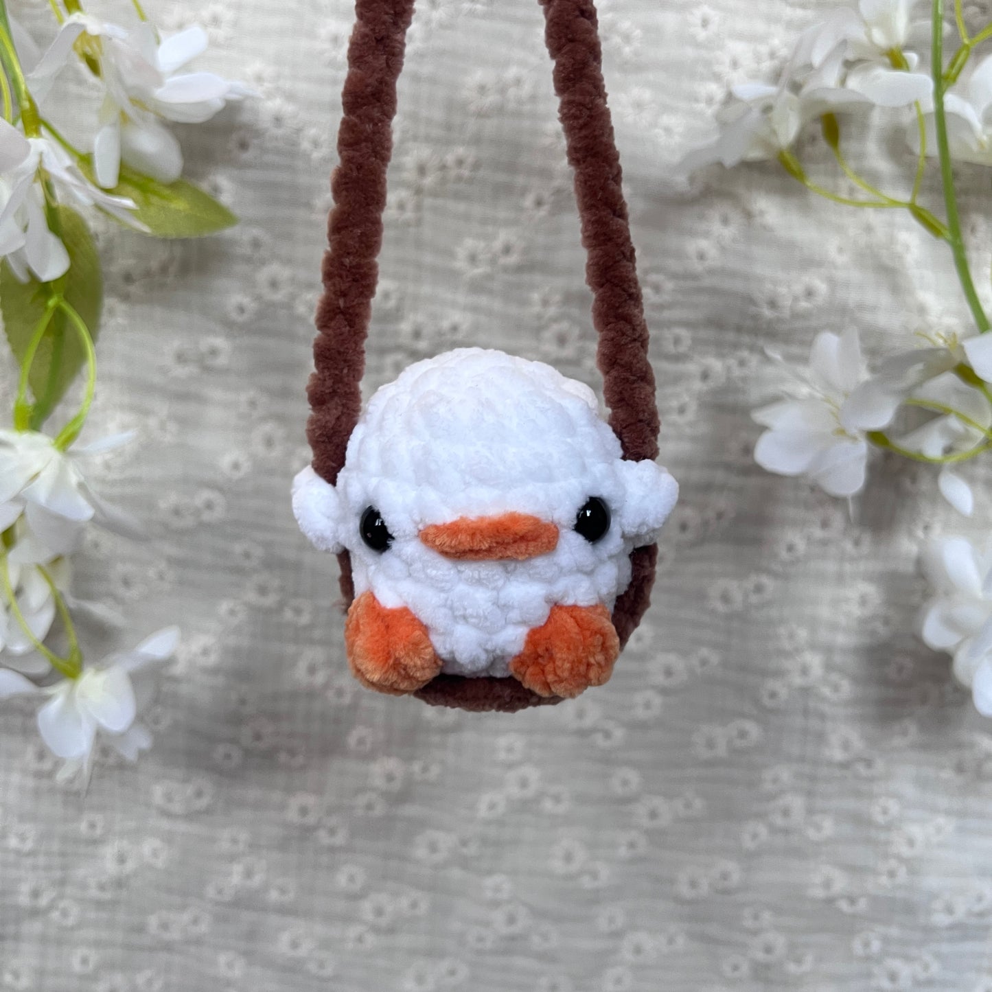 Décoration rétroviseur poussin blanc avec une balançoire marron en crochet