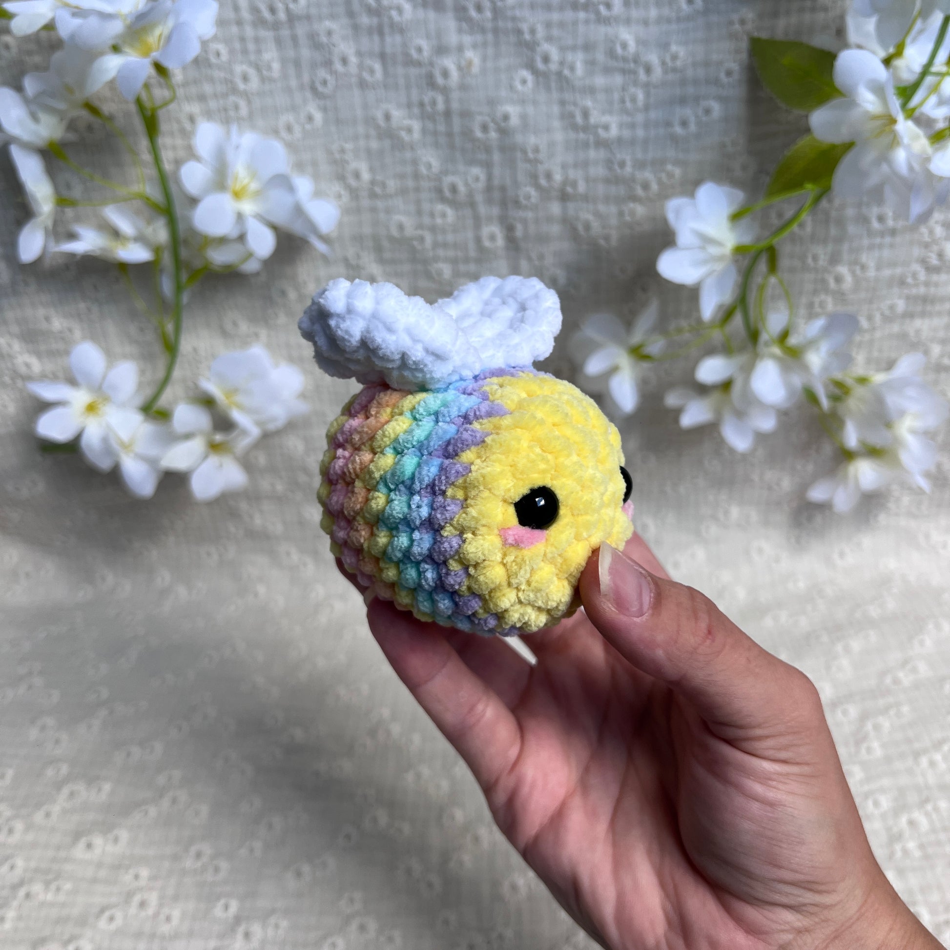 Peluche abeille multicolore pastel au crochet vue de gauche avec ses ailes blanches
